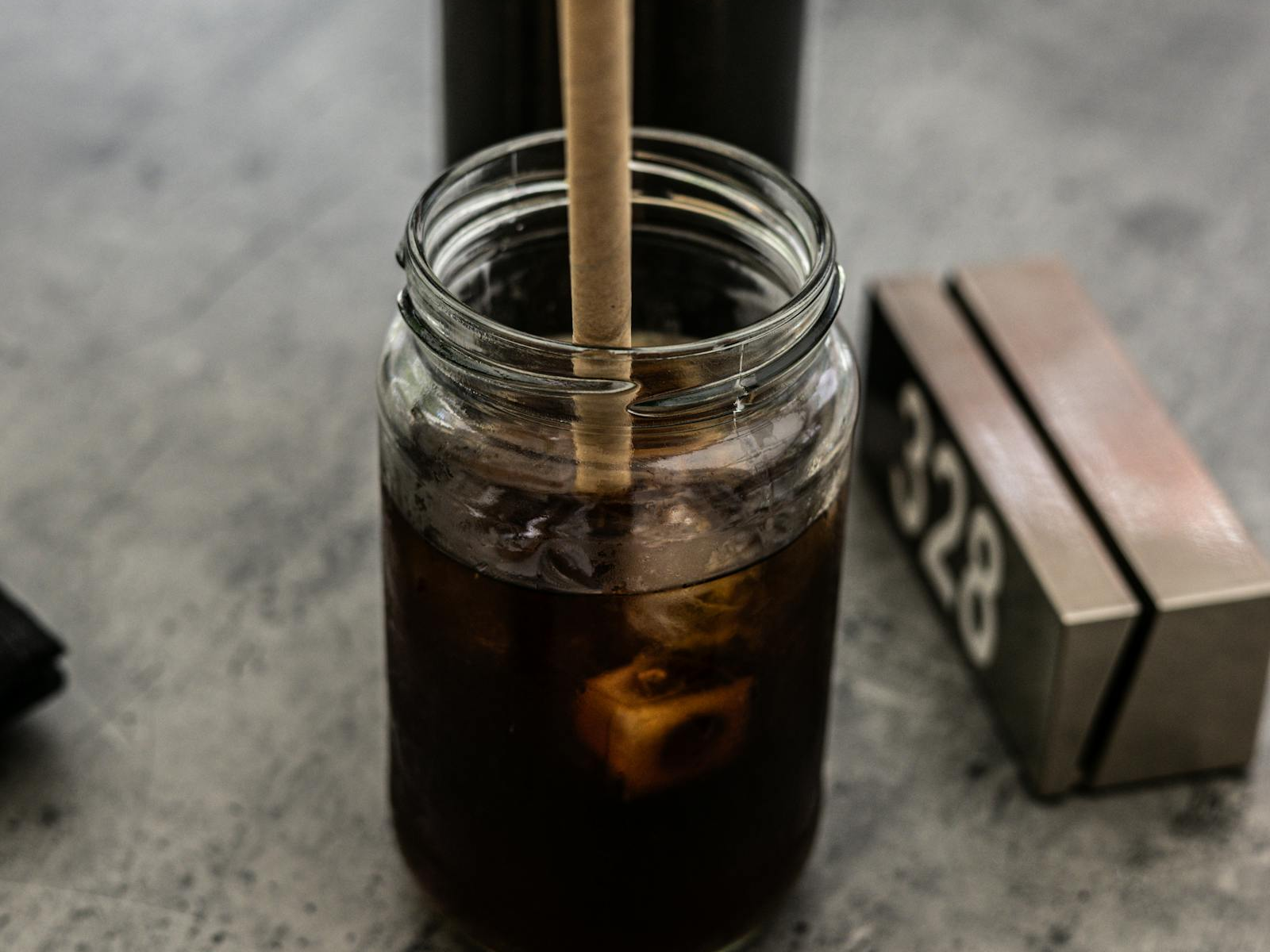 Iced coffee in a glass jar with straw for a cold brew tumbler routine